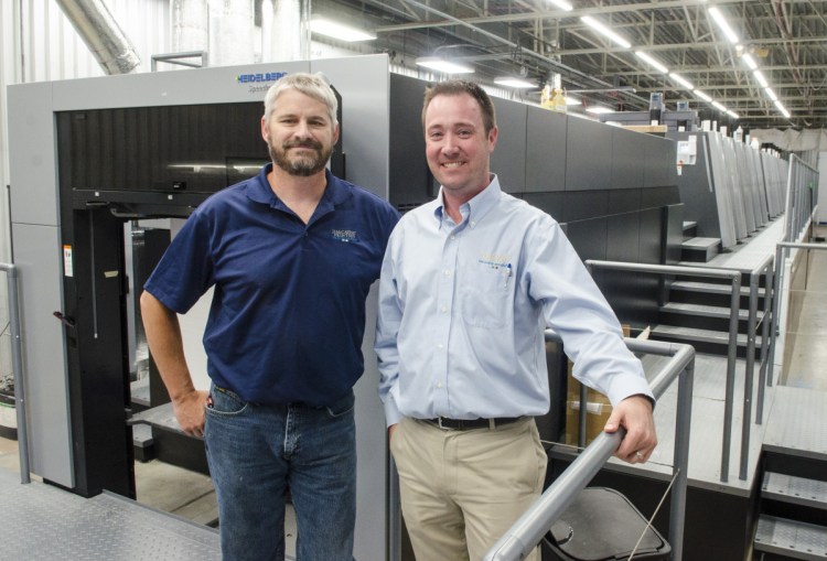 Press room manager Randy Robbins, left, and President and Chief Executive Officer Jon Tardiff pose with the new Heidelberg press on Friday at J.S. McCarthy in Augusta.