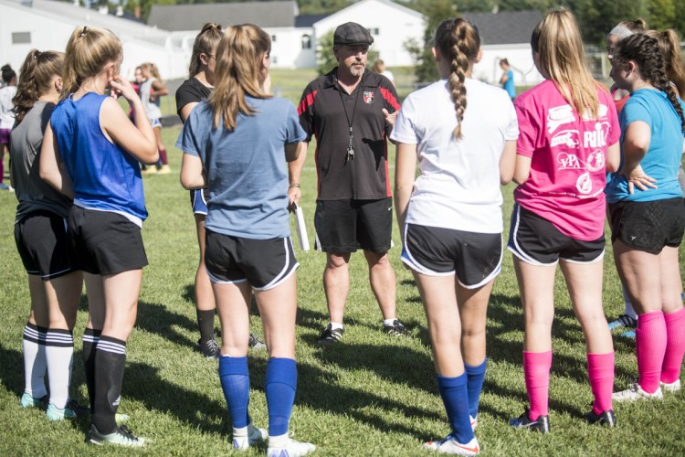 Mike Falla, center, new head coach of the Erskine Academy girls soccer team, talks to his players during practice last week in South China.