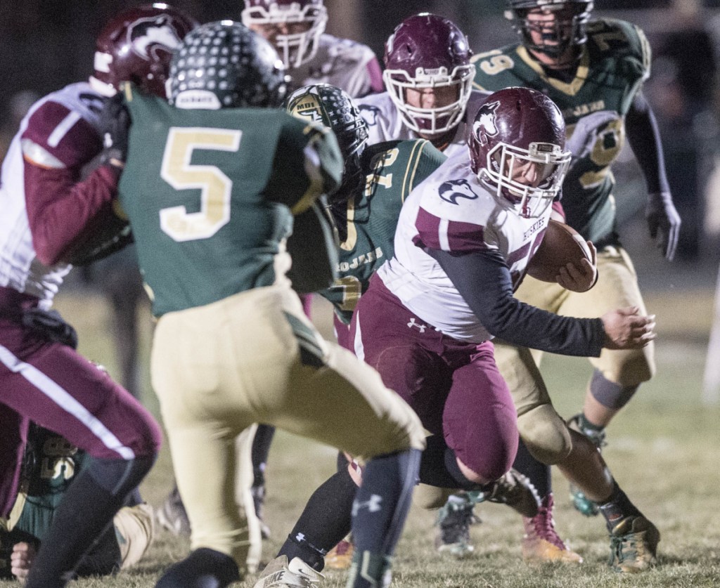 Maine Central Institute's Seth Bussell runs through the Mt. Desert Island line during the Class C North championship game last season night in Bar Harbor. The Huskies open their defense of their title at Leavitt on Friday night.