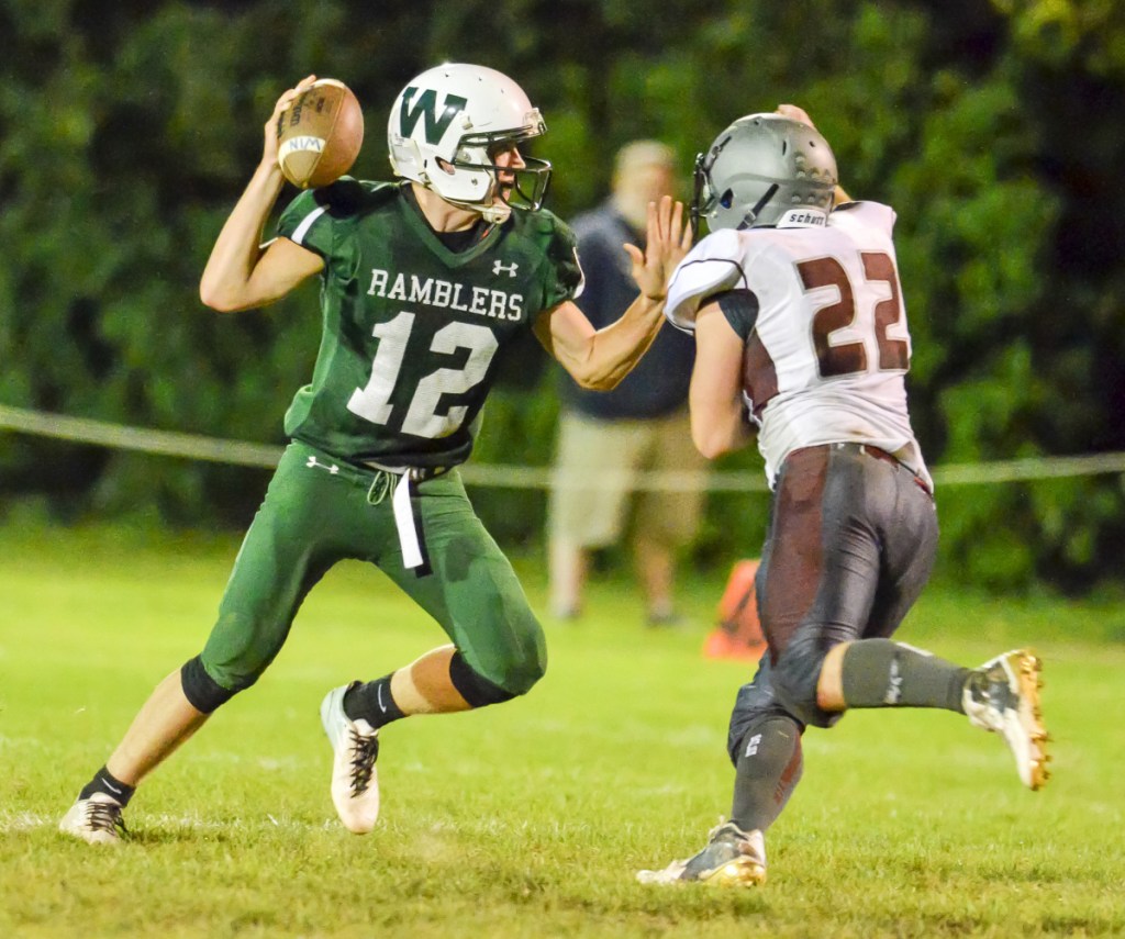 Staff file photo by Joe Phelan 
 Look out: Winthrop/Monmouth quarterback Keegan Choate tries to elude fast-charging Ellsworth linebacker Charlie Hughes during a Class D game last season at Maxwell Field in Winthrop.