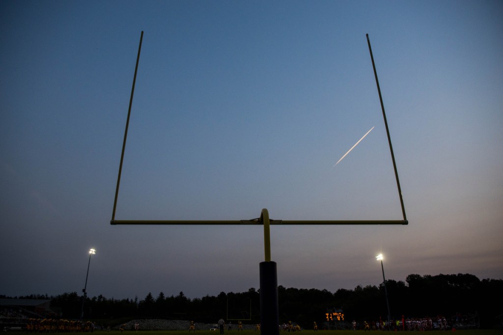 Staff photo by Michael G. Seamans 
 A jet's vapor trail splits the goal posts at Caldwell Field on the Mt. Blue High School campus in Farmington during an Aug. 24 preseason game betwen the Cougars and Cony Rams.