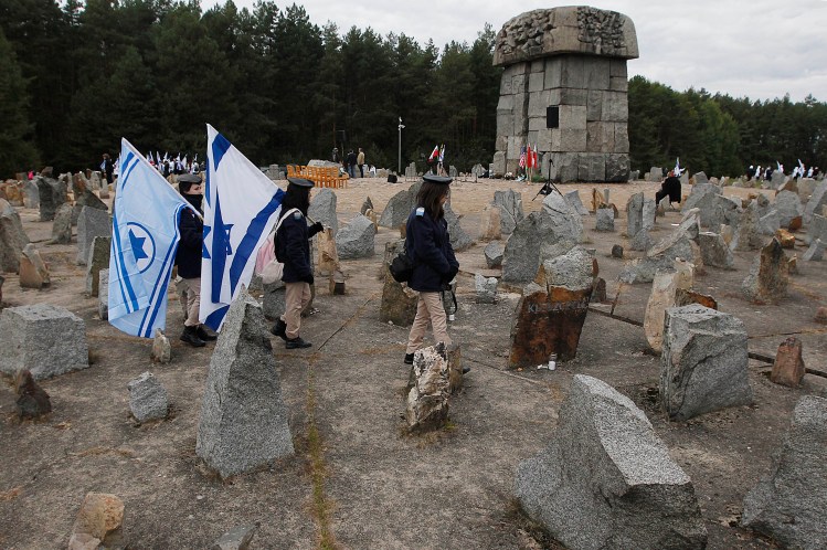 Israeli youths with national flags march in 2013 by the monument to some 900,000 European Jews killed by the Nazis between 1941 and 1944 at the Treblinka death and labor camp, at Treblinka memorial, Poland. 