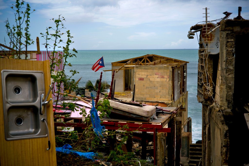 A Puerto Rican national flag is mounted on a damaged home in the seaside slum of La Perla, San Juan, in the aftermath of Hurricane Maria on Oct. 5. An independent investigation ordered by Puerto Rico’s government estimates that nearly 3,000 people died as a result of Hurricane Maria. The findings by the Milken Institute School of Public Health at George Washington University contrast sharply with the official death toll of 64. 
