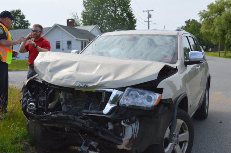 Jay Police Officer David Morin, left, speaks with Russell Bailey, 31, of Farmington on Tuesday morning after his Jeep Cherokee and a Chevrolet Malibu driven by Scott Moore, 50, of Auburn, collided at Routes 133 and 156 in Jay. 