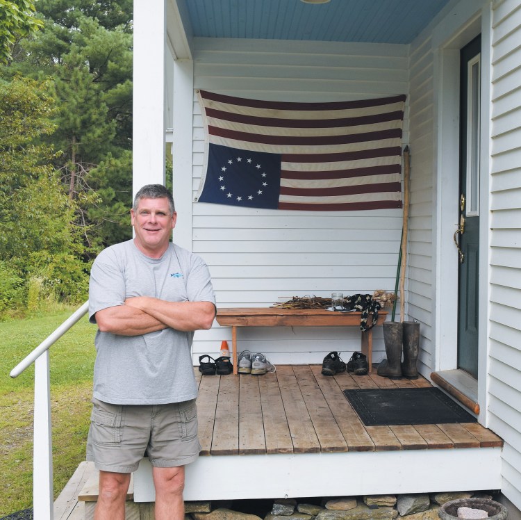 Bowdoinham resident Gregg McNally stands by the flag that has drawn attention from passers-by on Ridge Road. McNally said his intentions aren’t to disrespect the flag, but to signal what he sees as a state of distress in the nation. 