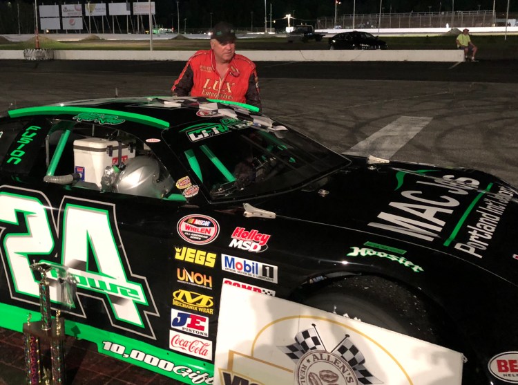 Mike Rowe of Turner climbs out of his car after winning the Super Late Model feature Saturday night at Oxford Plains Speedway in Oxford.