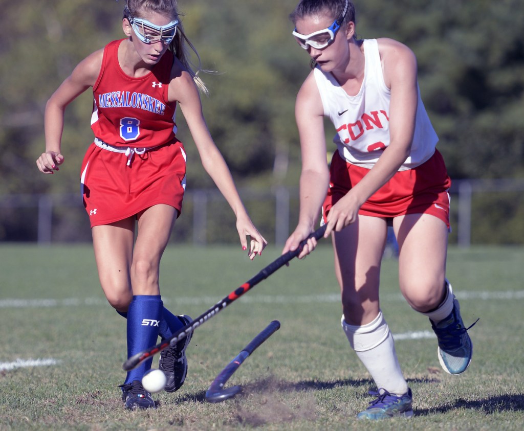 Cony's Anna Stolt, right, knocks the stick away from Messalonskee's Megan Quirion during a field hockey game Thursday in Augusta.