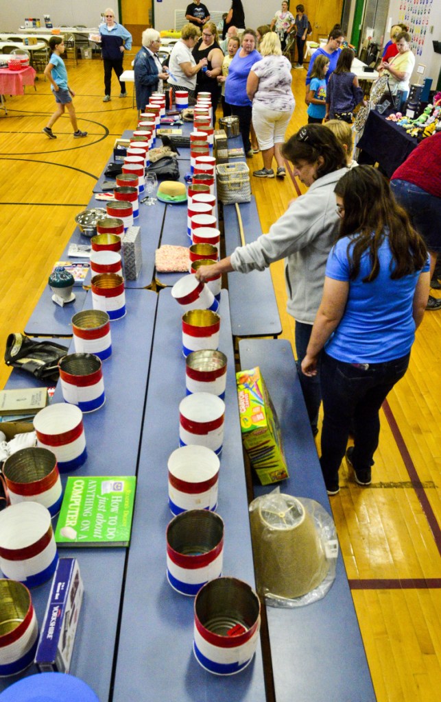 People try to decide into which bucket to put their Somerville Day raffle tickets Saturday at Somerville Elementary School.