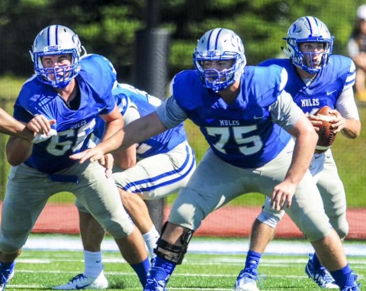 Colby College offensive linemen Ty Mahar, left, and Brandon Troisi block for quarterback Jack O'Brien during a game against Trinity earlier this in Waterville.