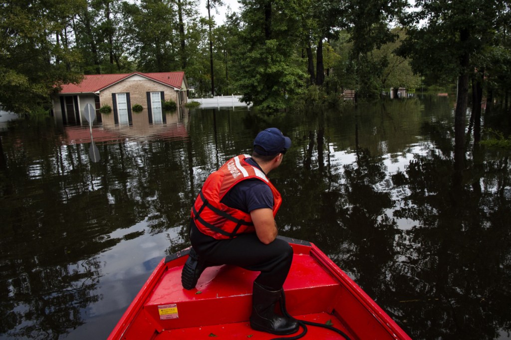 Boatswain's Mate Dimitri Georgoulopoulos looks out as members of a punt team with the United States Coast Guard preform searches through floodwater in the MayFair neighborhood of Lumberton, North Carolina, in the aftermath of Hurricane Florence on Monday.
