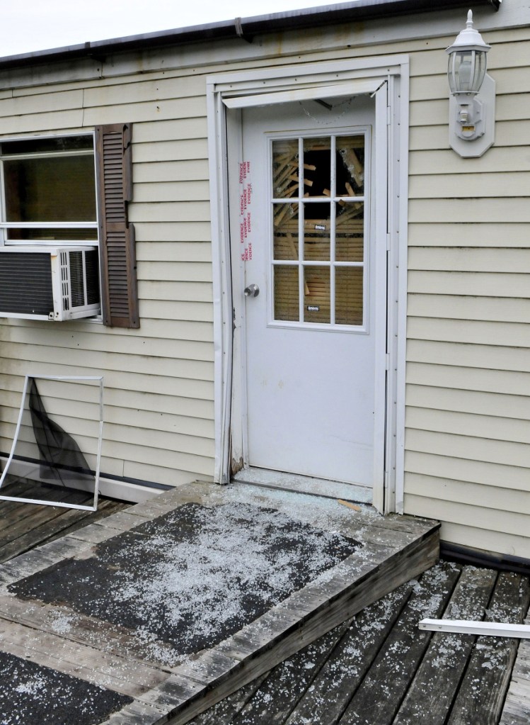 Glass from a shattered window in a door that is sealed with police evidence tape is seen at the front entrance to a mobile home at 1003 Oakland Road in Belgrade on May 22, 2017. Homeowner Roger Bubar died in a police officer-related shooting on May 19, 2017, and his son Scott Bubar now is standing trial on a charge of attempted murder of a police officer.