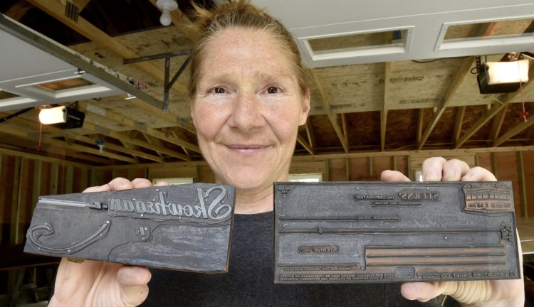 Kim Wilson on Tuesday holds metal plates used in printing newspapers that are part of a collection of hundreds of editions of Somerset County newspapers dating back to the mid-1800s that will become part of an extensive collection in Skowhegan. On the block at left, "Skowhegan, Me." is engraved backward.
