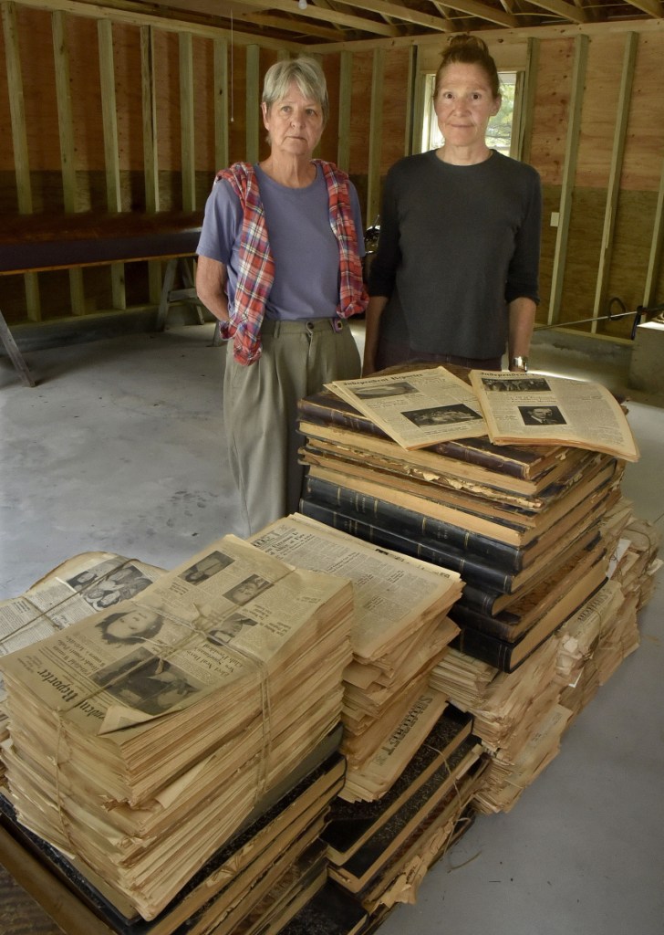 Patricia Horine, left, and Kim Wilson display on Tuesday some of the hundreds of editions of Somerset County newspapers dating back to the mid-1800s that will become part of an extensive collection in Skowhegan.