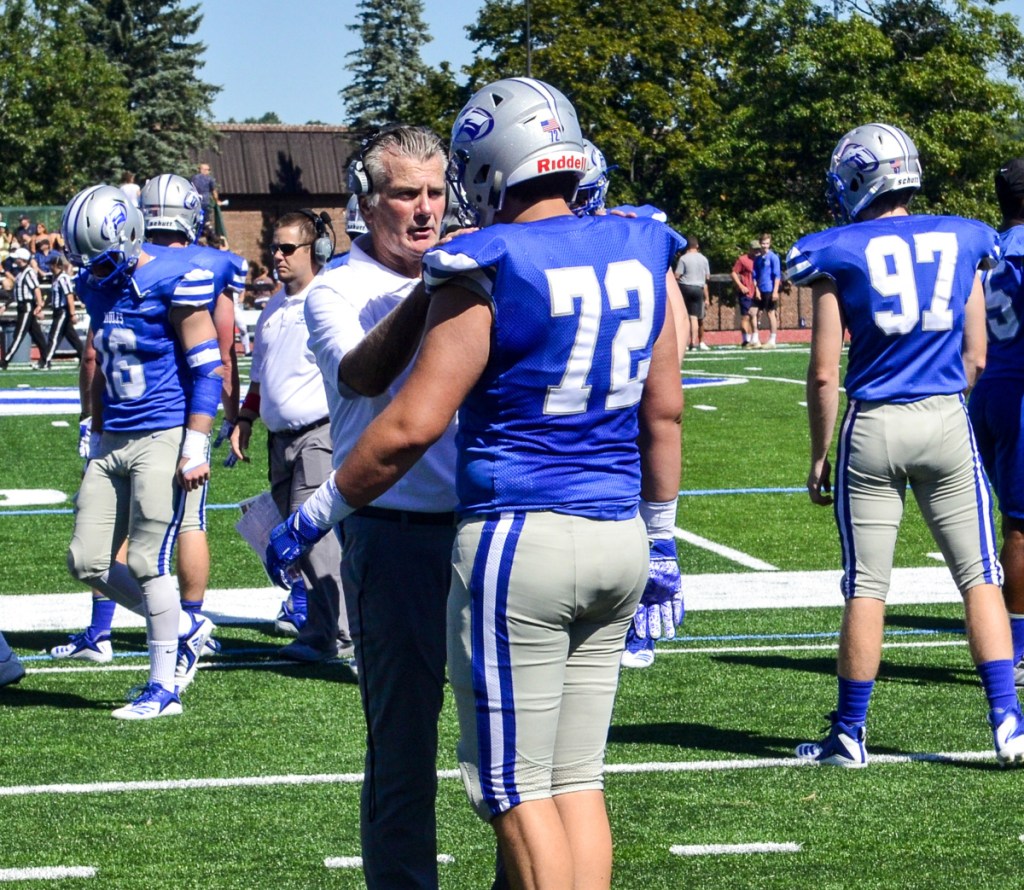 New Colby College head football coach Jack Cosgrove talks with a player before a game against Trinity on Saturday in Waterville.