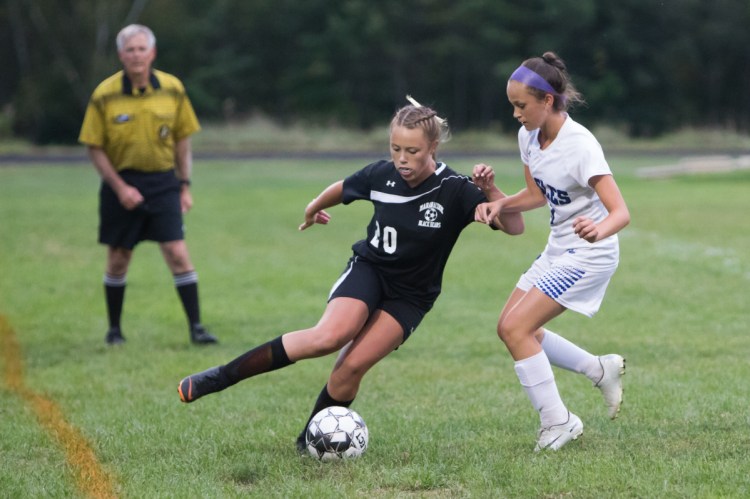 Maranacook's Ella Delisle takes control of the ball while Erskine's Mackenzie Roderick defends her Thursday in Readfield.