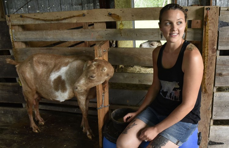 Farmer Kassie Dwyer takes a break from milking a goat named Diamond on July 17 at the Eden farm in Athens. Dwyer has proposed a local food ordinance that would allow locally grown foods to be sold without licenses and inspections.