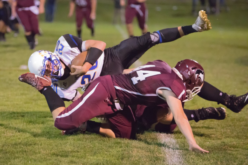 Hermon's Garrett Trask gets wrapped up by Maine Central Institute defender Kempton Roy during a Class C North game Friday night in Pittsfield.