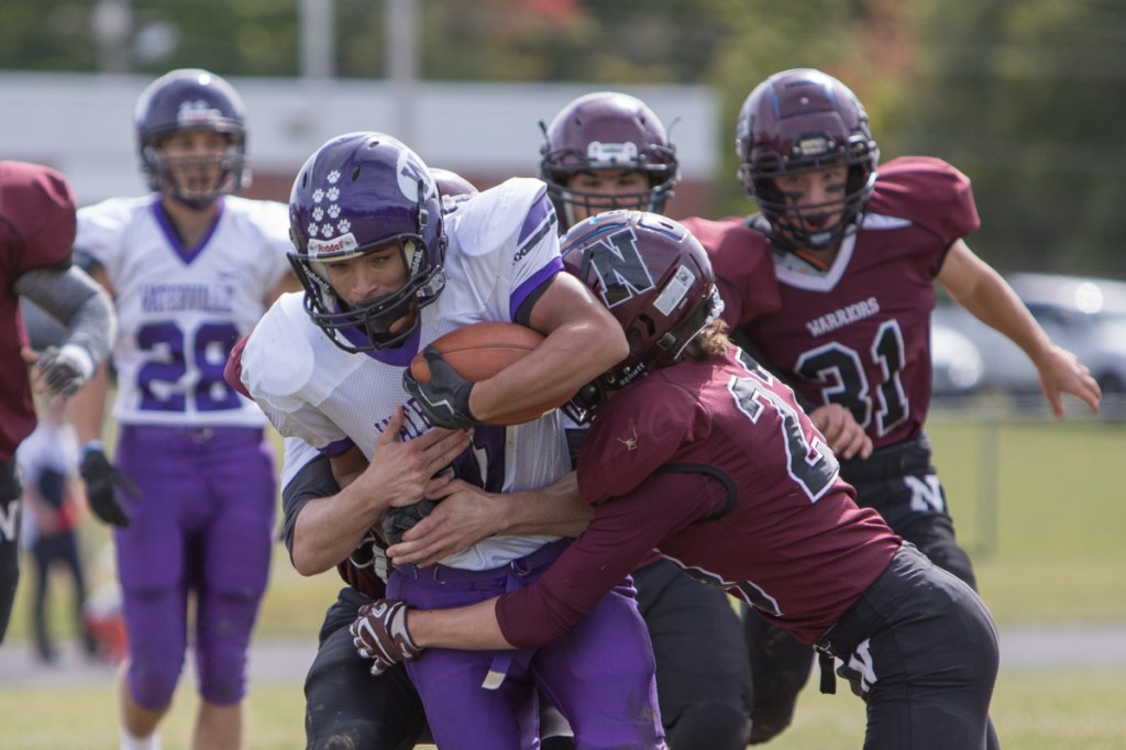 Waterville running back Anthony Singh gets wrapped up by Nokomis defender Beau Briggs during a Class C North game Saturday in Newport.