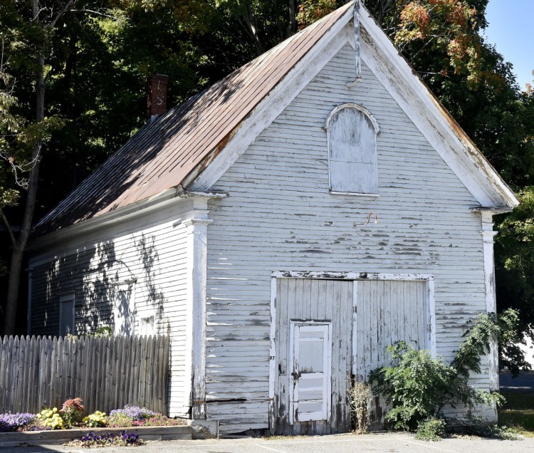 Oakland town councilors decided Monday to accept Norman Vigue's bid to buy the former school building at 97 Church St. that sits next to his residence and business.
