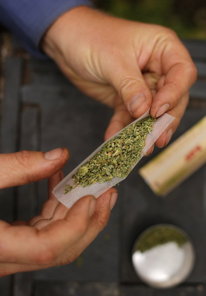 A smoker rolls a marijuana cigarette in Portland Oct. 11, 2013.