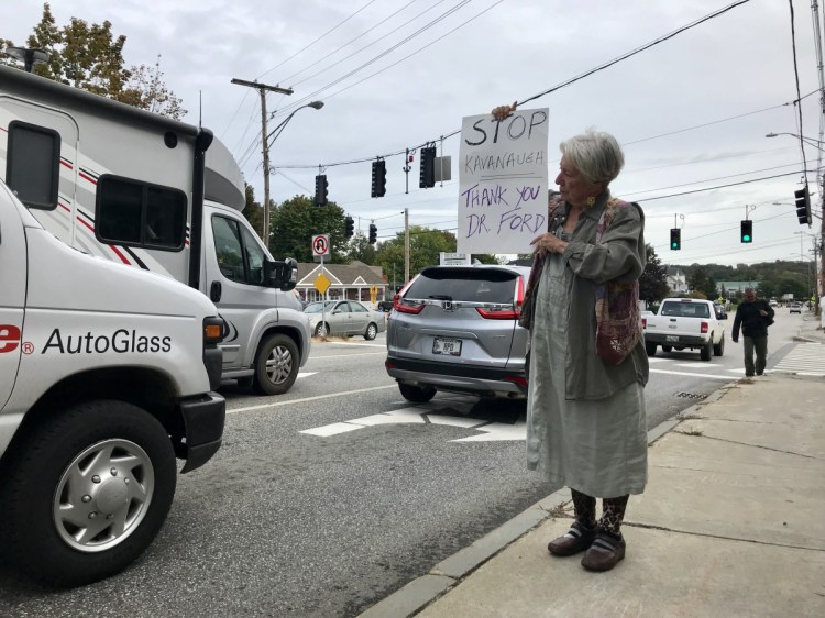 Tova Starbird-DeVos, of Hallowell, displays a sign protesting the potential confirmation of Judge Brett Kavanaugh as a Supreme Court justice on Friday afternoon outside U.S. Sen. Susan Collins's office at the Edmund S. Muskie Federal Building in Augusta.