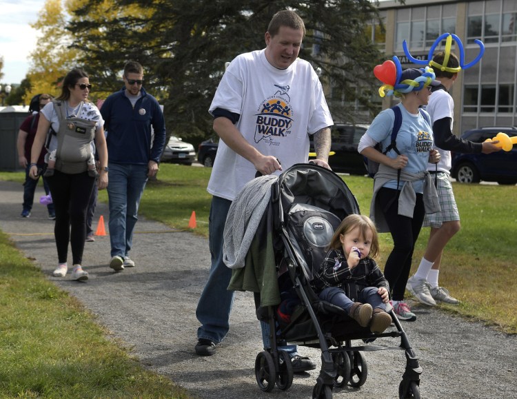 Luna Sorenson, 1, of Rumford, accompanies her father, Tom, on Sunday on the Augusta Buddy Walk, presented by the Maine Down Syndrome Network.