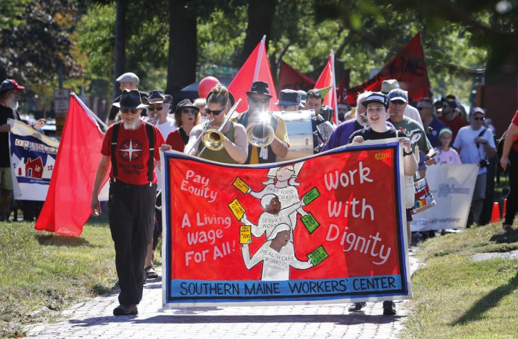Participants in the Southern Maine Labor Council AFL-CIO's march proceed Monday along State Street in Portland.