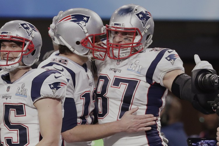 Quarterback Tom Brady has one of his top weapons, Rob Gronkowski, right, back and the tight end is happy after the Patriots added incentives to his contract.