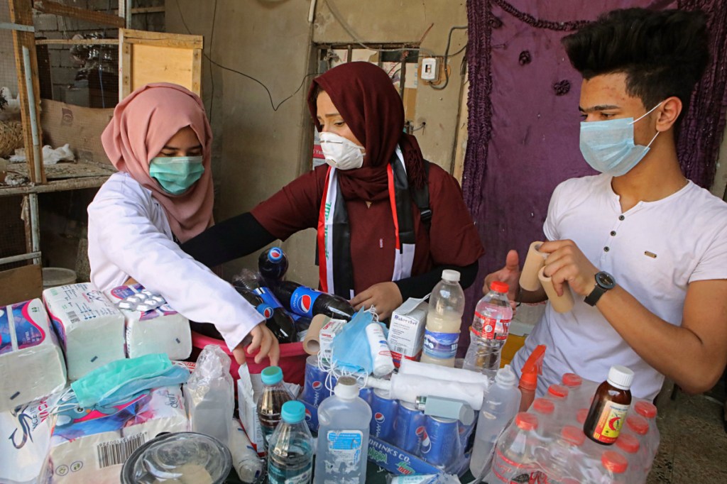 Duhaa Mayaa, center, and her two children prepare first aid supplies for injured protesters in their home in Basra, Iraq. With brackish water pouring from the taps, failing city services and soaring unemployment, the southern Iraqi city has seen weeks of violent protests in the streets.