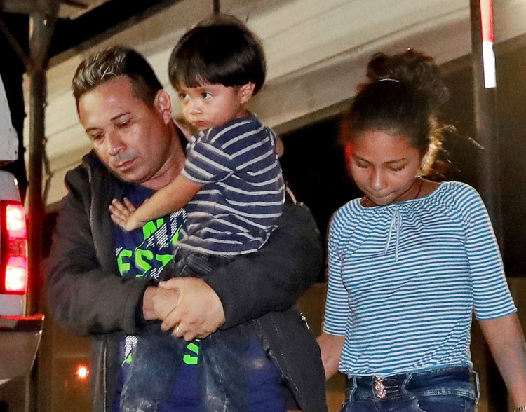 A Honduran man and his children proceed to a transport vehicle after being detained July 18 by Border Patrol agents in San Luis, Ariz.