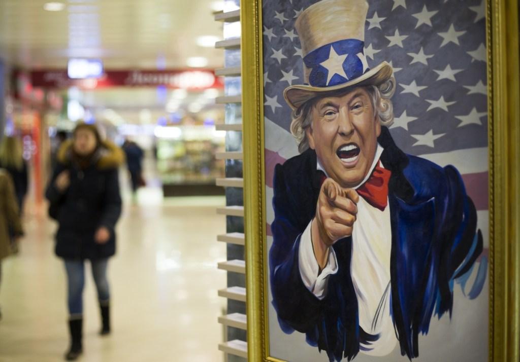 People walk past a caricature picture of President Trump on sale in a shopping mall in Moscow.  Trump's executive order authorizing sanctions on foreigners who mess with American elections could herald new headaches for Russia.