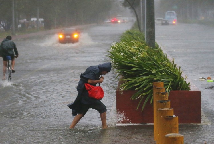 Commuters in Manila brave rain and strong winds from Typhoon Mangkhut, which barreled into the northeastern Philippines before dawn on Saturday.