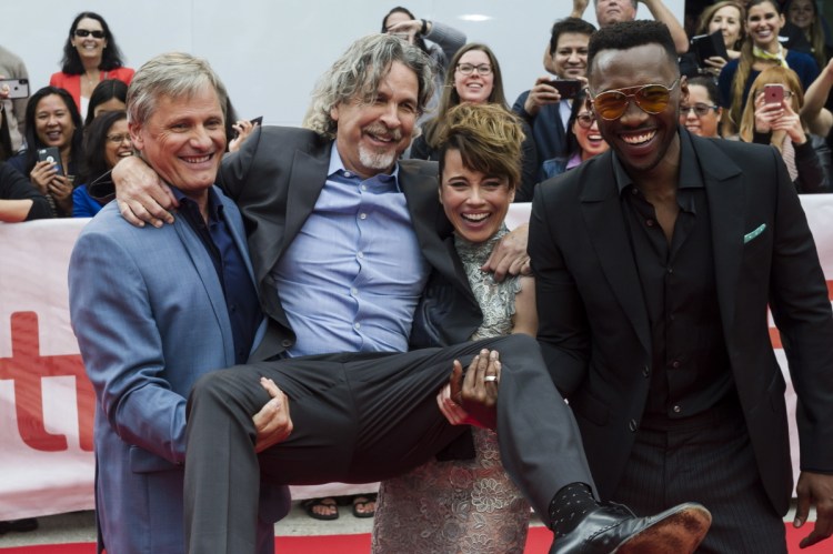 Director Peter Farrelly is lifted up by actors, from left, Viggo Mortensen, Linda Cardellini and Mahershala Ali as they arrive for the screening last week of "Green Book" at the Toronto International Film Festival.