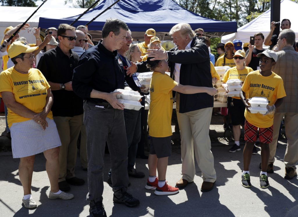 President Trump and North Carolina Gov. Roy Cooper, left, greet volunteers as they prepare to hand out food at Temple Baptist Church, where food and other supplies are being distributed during Hurricane Florence recovery efforts on Wednesday in New Bern, N.C. 
