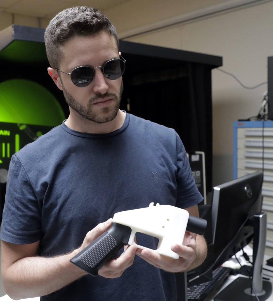 Cody Wilson, with Defense Distributed, holds a 3D-printed gun at his shop in Austin, Texas. A federal court barred him from posting the gun blueprints online.