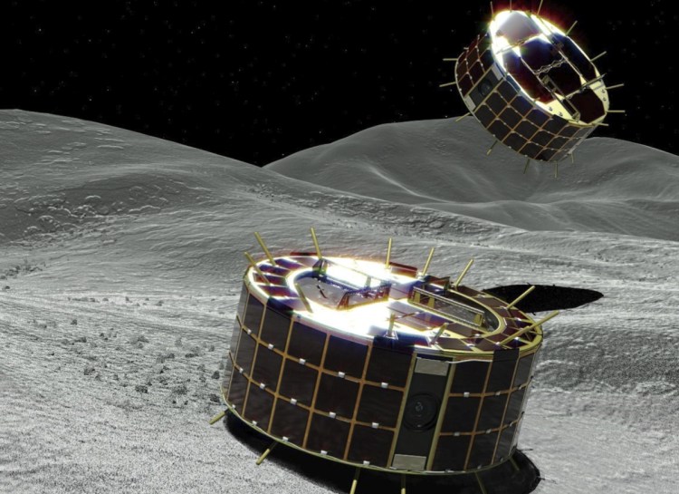 This computer graphic image provided by the Japan Aerospace Exploration Agency shows two drum-shaped and solar-powered Minerva-II-1 rovers that were released on an asteroid on Friday.