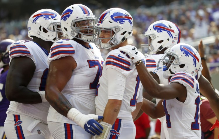 Bills quarterback Josh Allen, center, celebrates with teammates after scoring on a 10-yard run Sunday against the Vikings. Allen ran for two TDs and passed for one in a 27-6 win.