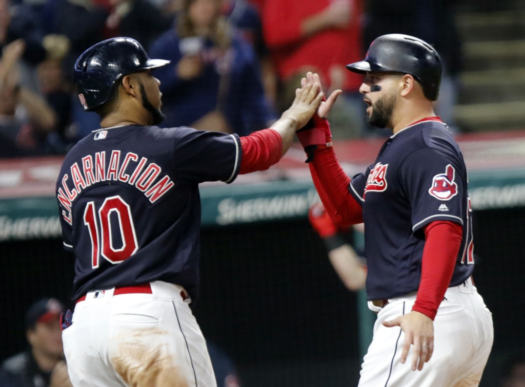 Cleveland's Edwin Encarnacion, left, and Yonder Alonso celebrate after scoring on a double by Melky Cabrera in the fourth inning Sunday night against the Boston Red Sox. The Indians won in 11 innings, 4-3.