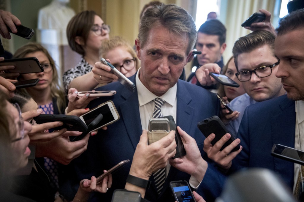 Sen. Jeff Flake, R-Ariz., center, speaks with reporters after meeting with Senate Majority Leader Mitch McConnell at his office in the Capitol in Washington on Friday. The Senate Judiciary Committee advanced Brett Kavanaugh's nomination for the Supreme Court after agreeing to a one-week investigation into sexual assault allegations against the high court nominee.