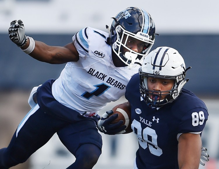 Manny Patterson of the University of Maine reaches for D. Major Roman of Yale during Saturday's game at the Yale Bowl in New Haven, Conn. Yale defeated Maine 35-14.