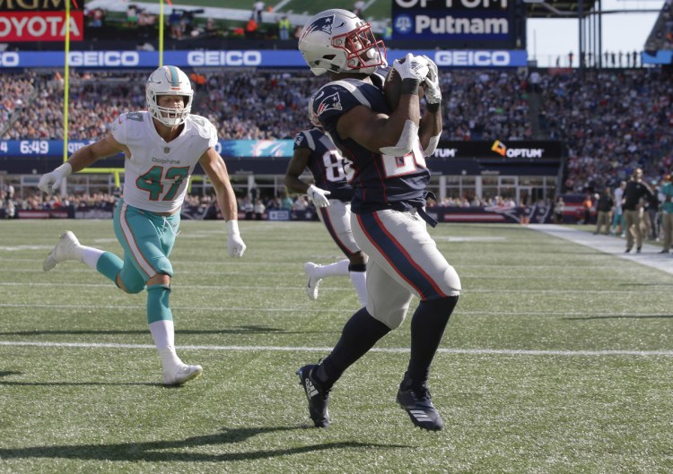 Patriots running back James White, right, catches a touchdown pass in the front of Miami Dolphins linebacker Kiko Alonso during the second half of the Patriots' 38-7 win Sunday in Foxborough, Mass.