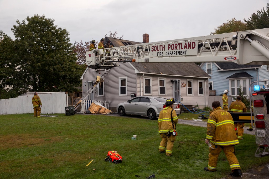 Firefighters finish putting out a fire in the second floor of a single family home at 12 Calais Street on Tuesday morning. South Portland Fire Chief James Wilson said the fire most likely started from an electrical problem, but they can't be certain until later. Both occupants of the home and their dogs were awake when the fire started and safely evacuated. 