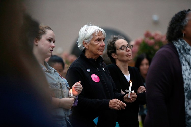 Susan Johnston, center left, of Cape Elizabeth and Claudia Sayre of Kennebunk listen to one of five speakers at a candlelight vigil Thursday in Portland's Congress Square Park. The vigil was held in solidarity with sexual assault survivors and inspired by Christine Blase Ford's decision to testify against Judge Brett Cavanaugh before the Senate Judiciary Committee.