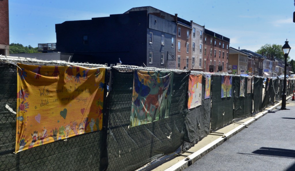 A few of the murals hanging on the fence Friday along Water Street in Hallowell.