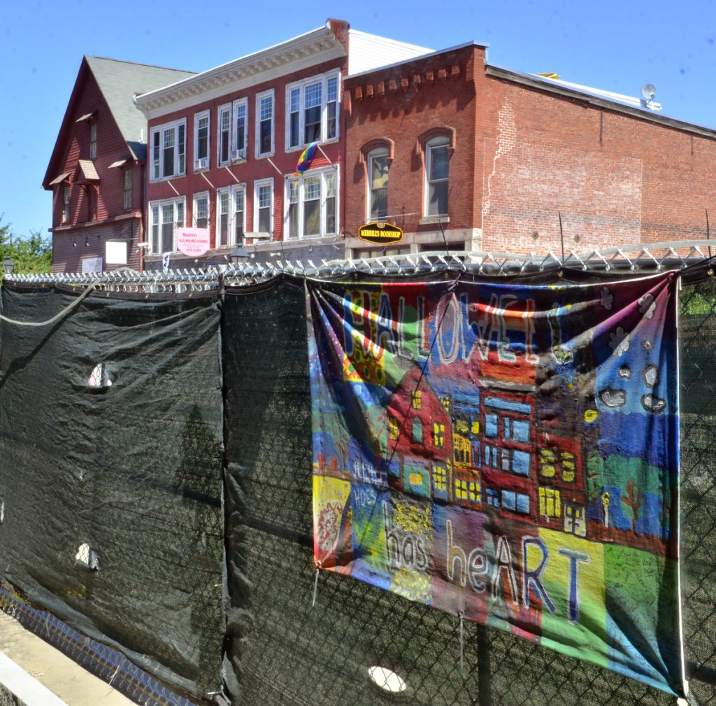 A murals hanging on the fence Friday along Water Street in Hallowell.