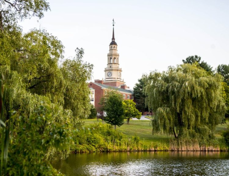 Miller Library towers over campus as it reflects in Johnson Pond at Colby College in Waterville on Saturday.