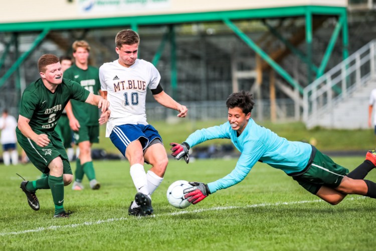Oxford Hills goalkeeper Sam Morton comes out of the net to deny Mt. Blue's Sam Smith in first-half action at Gouin Athletic Complex in Paris on Tuesday.