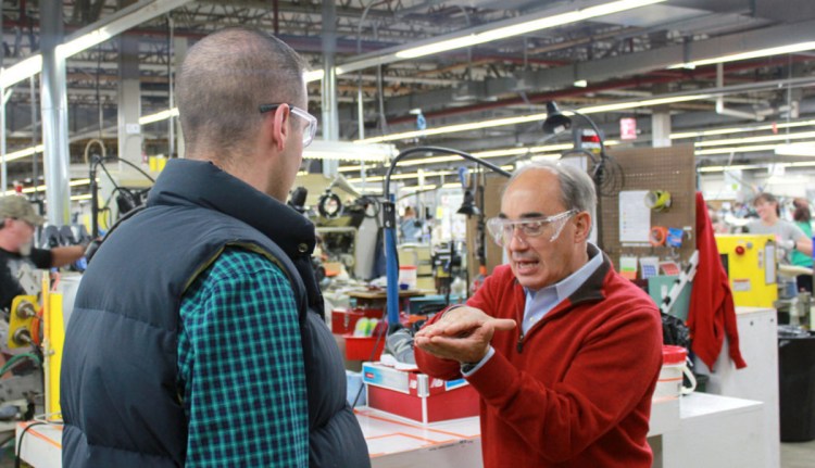 U.S. Rep. Bruce Poliquin, R-Maine, right, talks with John Alvarez, public affairs manager of New Balance, in October 2016 about the methods New Balance uses to put soles in their shoes.