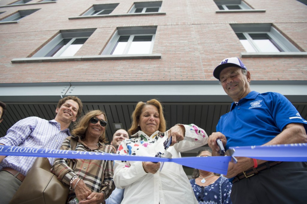 Joan Alfond, center, and Bill Alfond, right, cut the ribbon Wednesday at the Bill & Joan Alfond Main Street Commons public opening in Waterville.