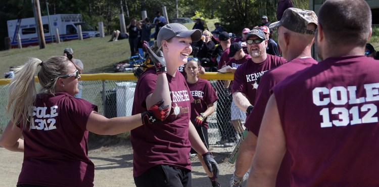 Brittany Johnson, left, congratulates Beth Fischer Sunday after she hit a grand slam for the Kennebec Sheriff's Department's softball team during the Fraternal Order of Police tournament in Sidney.